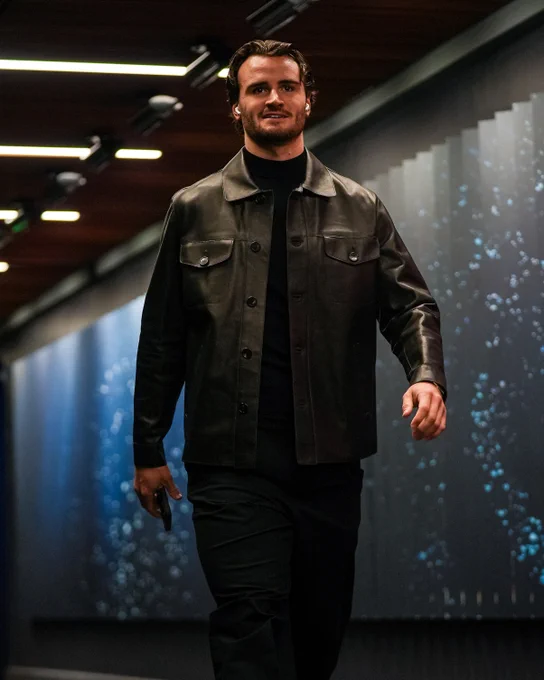 a photo of Seattle Kraken goaltender Joey Daccord walking into tonight's game in an all-black ensemble. He is pictured closer & is smiling.