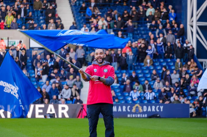 Cancer Kickers practitioner waving a flag.