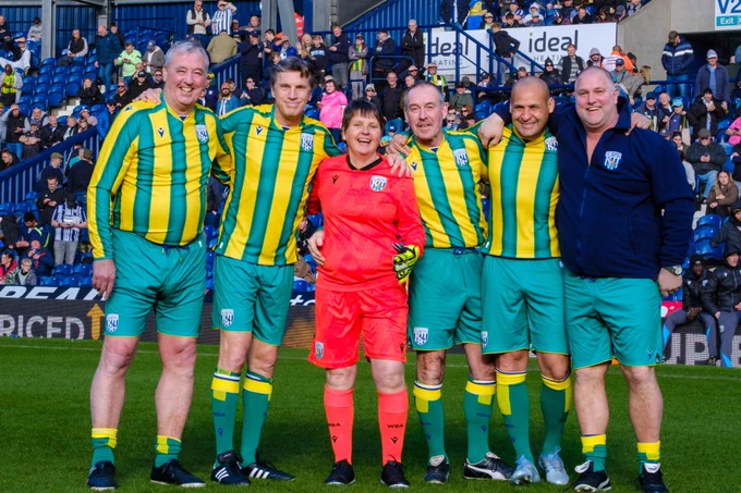 A smiling Cancer Kickers participant posing for a team photo with Joe Mayo, Andy Hunt, Bob Taylor, Nigel Quashie and Andy Johnson.