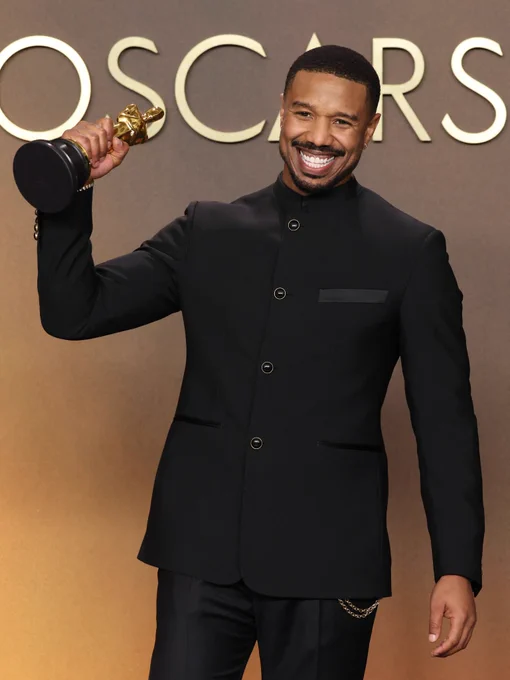 Michael B. Jordan holding his Oscar, smiling