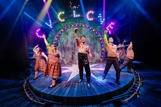 Teens punch the air on stage in Ride the Cyclone