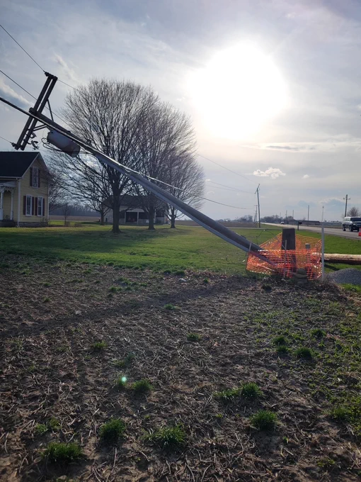 A utility pole sits at a 45 degree angle after being impacted by strong winds.