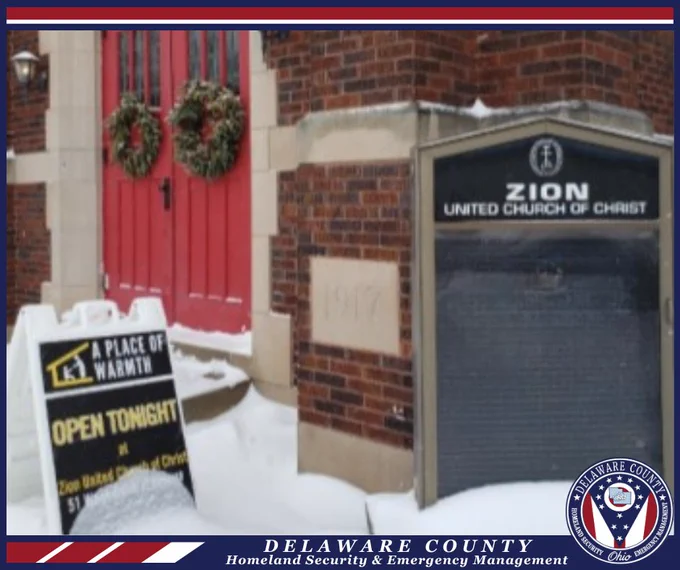 Entrance to Zion United Church of Christ with sandwich board sign announcing that A Place of Warmth is open tonight.