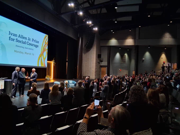 Chef Jose Andres accepts the award for social courage from President Cabrera and John Riberas on stage at Georgia Tech. A crowd watches.