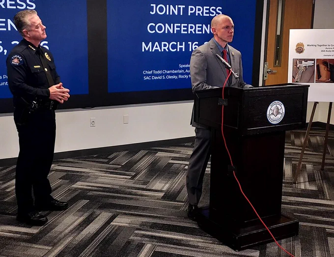 The Chief listens to SAC Olesky, speaking from a podium