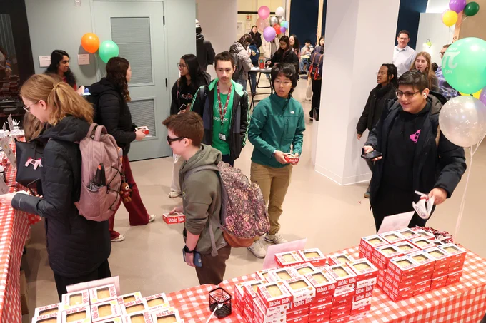 Students standing in line to pick up a pie.