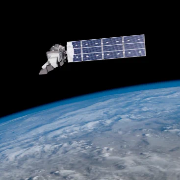Satellite with large solar panels orbiting above Earth’s blue and white cloud-covered surface.