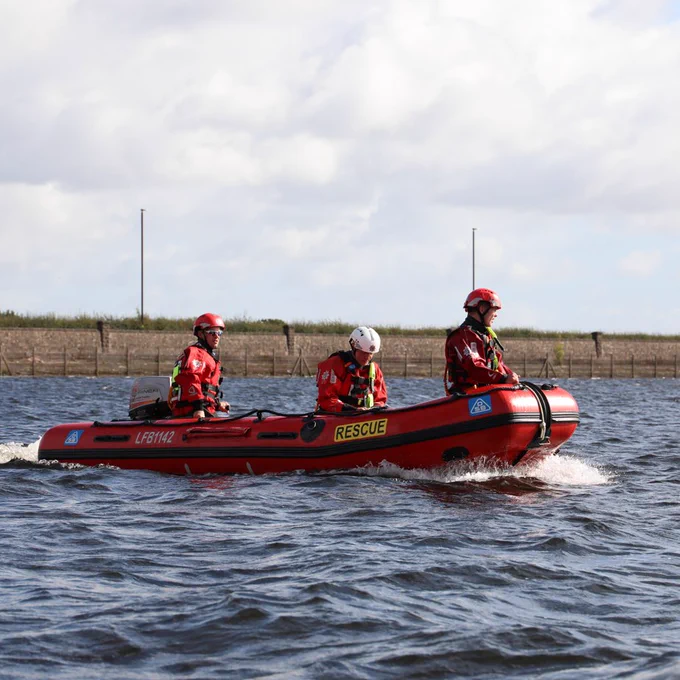 Firefighters on a red rescue boat