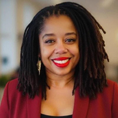 portrait of a Black woman smiling wearing red blazer