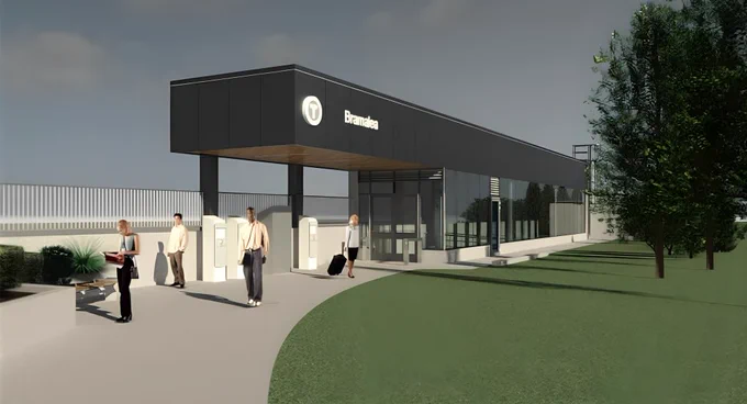 Une gare moderne portant l’inscription « Bramalea », avec des passants marchant sur un chemin sinueux près de l’entrée. La gare se distingue par son architecture épurée, alliant le noir et le verre, et est entourée de verdure et d’arbres.