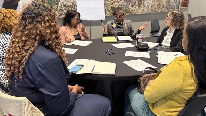A group of women discuss a topic during a strategy session