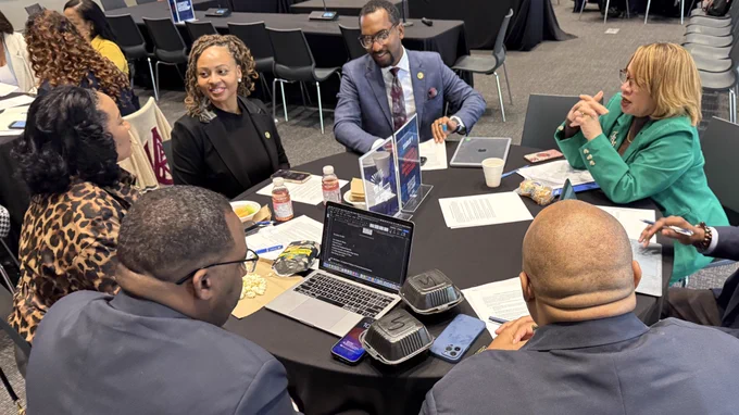 A group of administrators discuss a topic during a strategy session