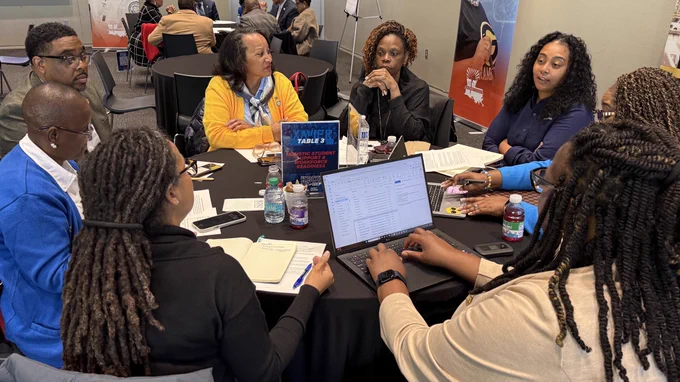 A group of administrators discuss a topic during a strategy session