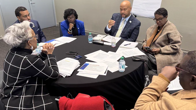 A group of administrators discuss a topic during a strategy session
