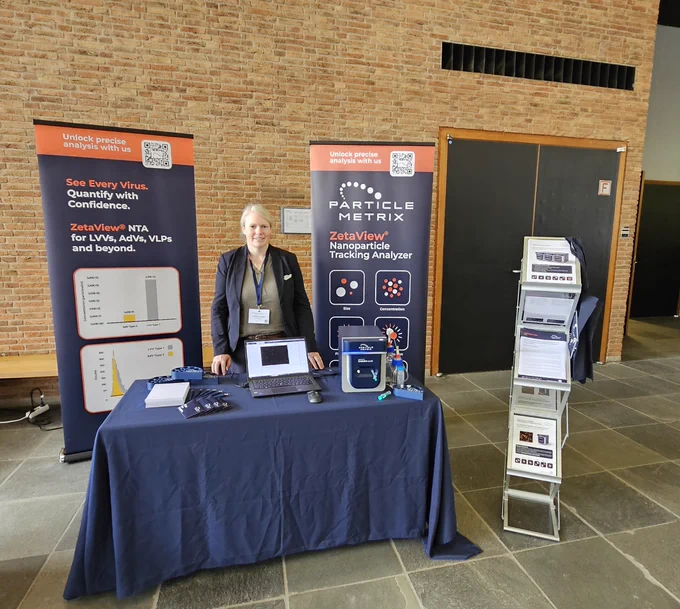 Christina Klasen and a ZetaView Evolution particle characterization device at the Particle Metrix exhibition booth at the GfV 2026 meeting.