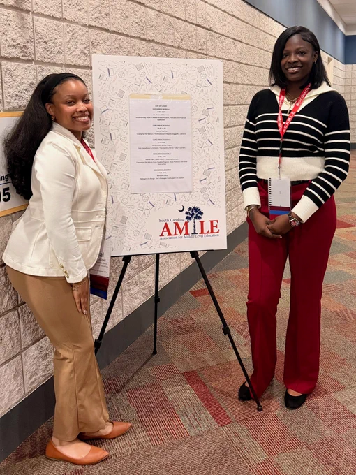 Two TIP teachers posing next to a South Carolina Association for Middle Level Education conference session board.