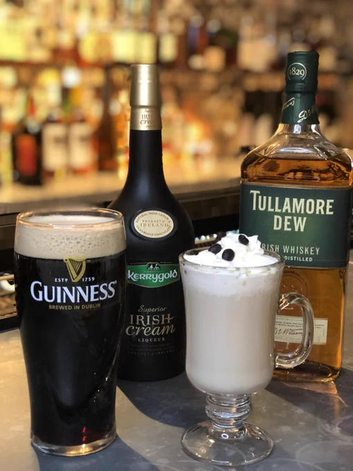 Showcasing several drinks, a glass of Guinness, Irish Cream, Tullamore Dew and a glass mug with beverage topped with whipped cream