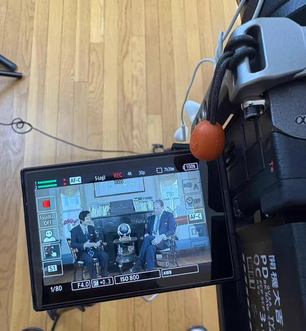 Close-up of camera with podcast episode on the screen