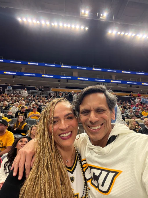 Selfie of Dr. Rao with a woman in a V-C-U jersey. Behind them is a stadium full of people.