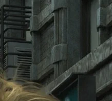 A demo screenshot from Resident Evil Requiem with "DLSS 5 OFF", showing the building behind Grace. The textures suggest concrete and stonework, with visible grain.