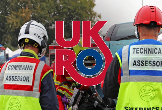 UKRO logo in between two assessors wearing PPE