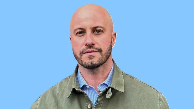 A headshot of Hofstra Law Professor Sergio Alberto Gramitto Ricci with a light blue background behind him.