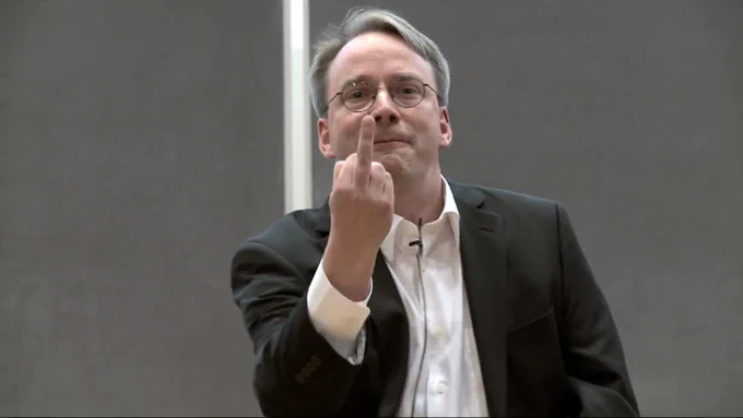 Linus Torvalds en una charla señalando con el dedo corazón hacia la cámara, con cara de quien acaba de descubrir un bug épico y ha decidido expresarlo de la forma más universal posible.