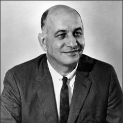Black and white portrait of a man wearing a suit and tie against a plain background.