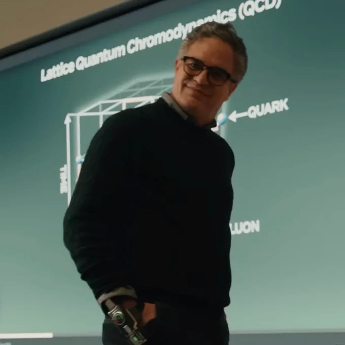 spider-man brand new day screenshot. bruce teaching a university course. the slideshow behind him says “Lattice Quantum Chromodynamics (QCD)”