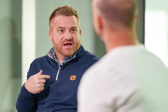 Photos of Head Coach Alex Golesh and Josh pate during an interview at the Woltosz Football Performance Center