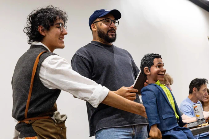 Director and puppeteer Bradley Freeman Jr., second from left, and a cast member play around during warmups ahead of a full run-through rehearsal of "Little Shop of Horrors" at UT San Antonio’s downtown campus on March 6, 2026. Credit: Amber Esparza / San Antonio Report