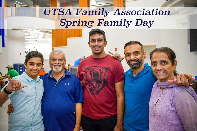 A group of five people standing and smiling at the camera. They are indoors, with "UTSA Family Association Spring Family Day" displayed at the top of the image.