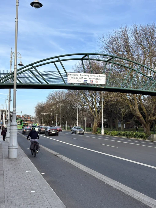 Image of Fairview footbridge with our banner calling for cost of living supports.