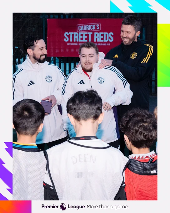 Michael Carrick, Mark Brent and a Foundation coach laugh and smile together in front of a group of participants.