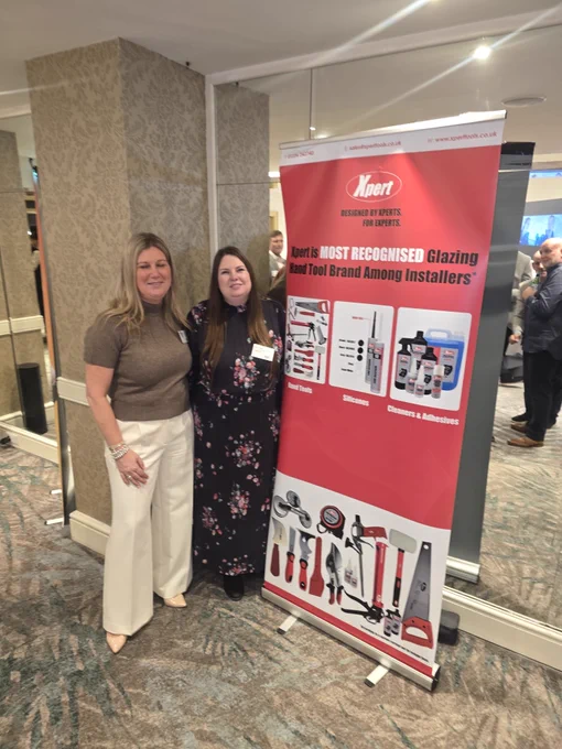 Window Ware MD Sam Nuckey and Xpert Tools' BDM Sarah Parker stand beside a red banner promoting Xpert as the most recognized glazing hand tool brand among installers, on displayed at the GGP Installer Awards 2026