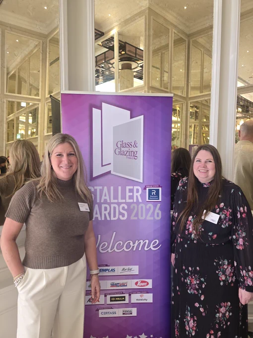 Window Ware MD, Sam Nuckey and Xpert Tools' Sarah parker standing beside a purple banner for the Glass & Glazing Installer Awards 2026.