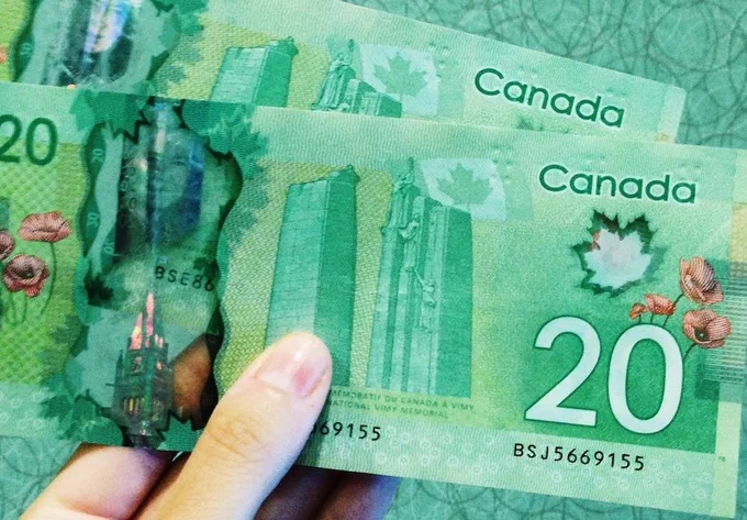 Two green $20 bills in Canadian currency. 