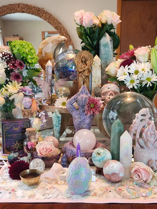 Ostara set up with oodles of crystals, candles, statues and flowers