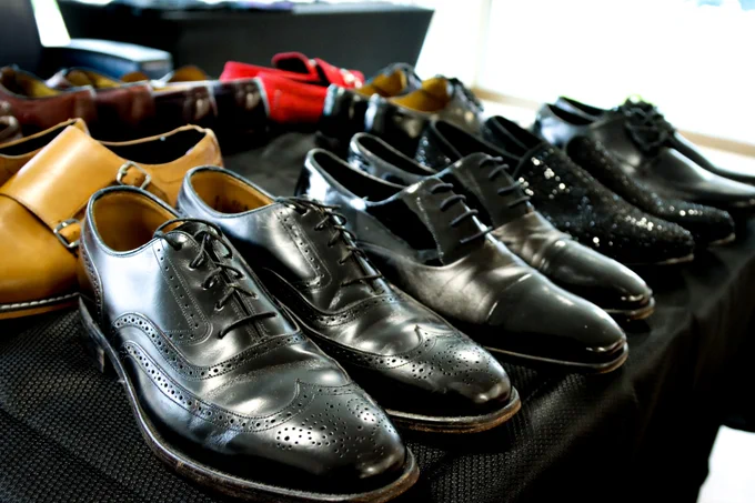 Black and brown dress shoes spread out on a table.