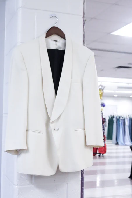 A white suit hanging up inside of a social hall.