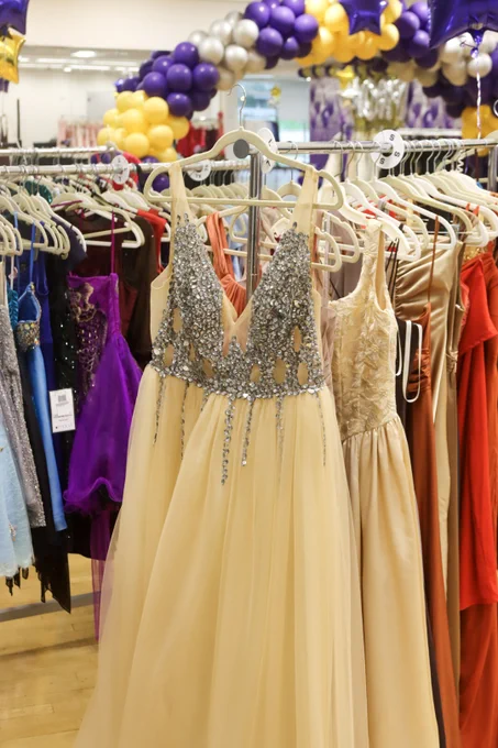 Beige and other colored dresses hanging on a rack.