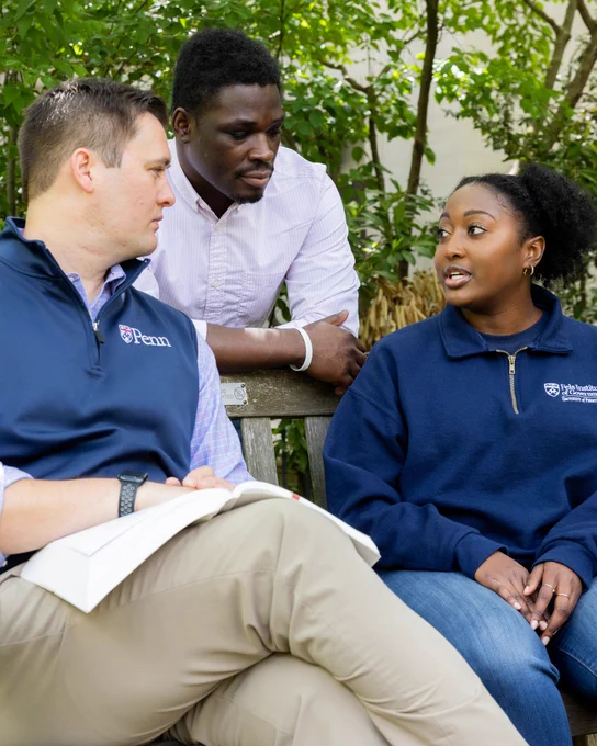 A group of Fels students gathered together talking. 