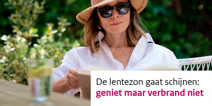Een vrouw zit met een zonnebril en hoed met brede rand in de schaduw een boek te lezen op de tafel voor haar staat een glas met water. De tekst: De lentezon gaat schijnen: geniet maar verbrand niet