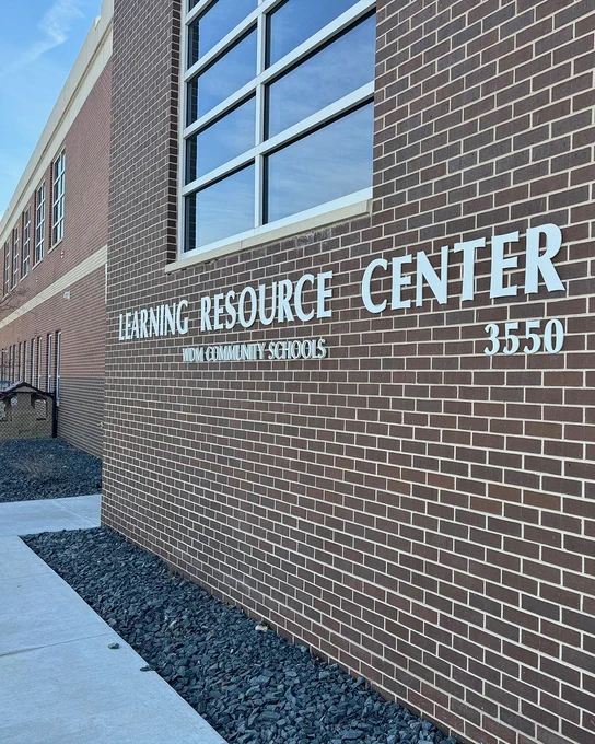 Exterior shot of a brick building with the words "Learning Resource Center" prominently displayed against a bright blue sky.