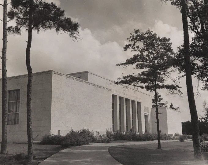black and white photo of the front of md anderson library with trees in foreground