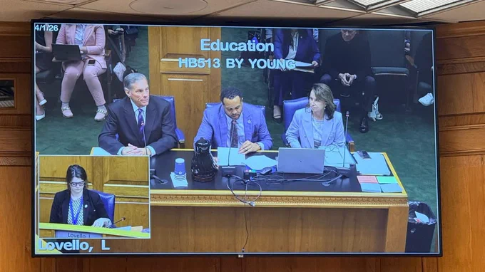 A photo of a TV featuring three people sitting at a table