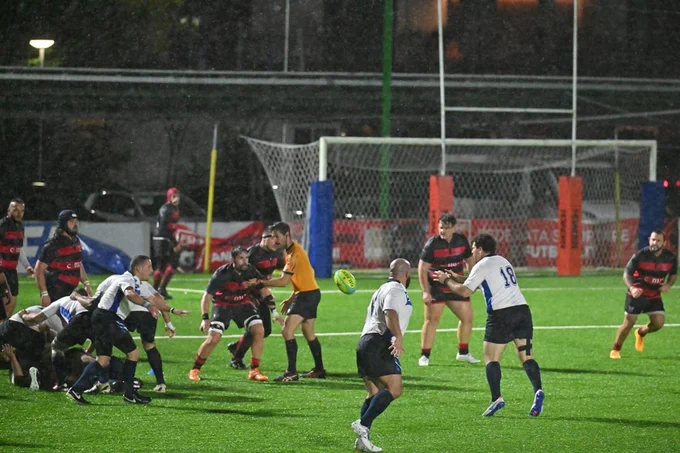 Two rugby teams play on a sports field