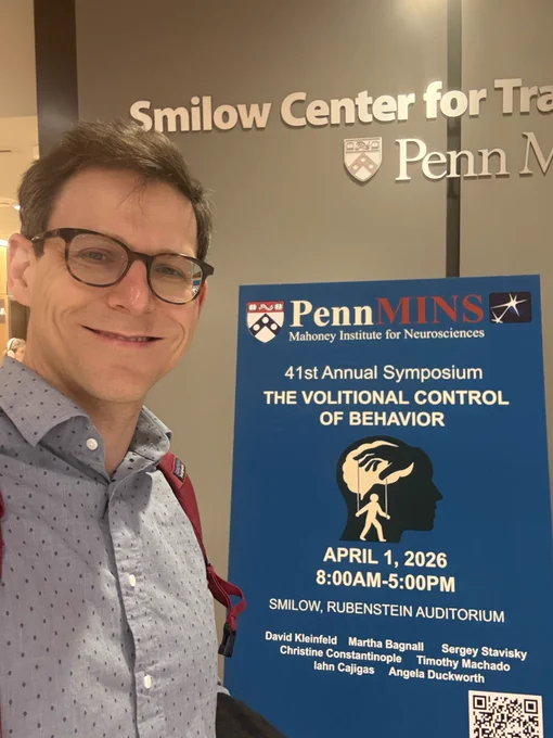 Sergey in front of a sign advertising the event