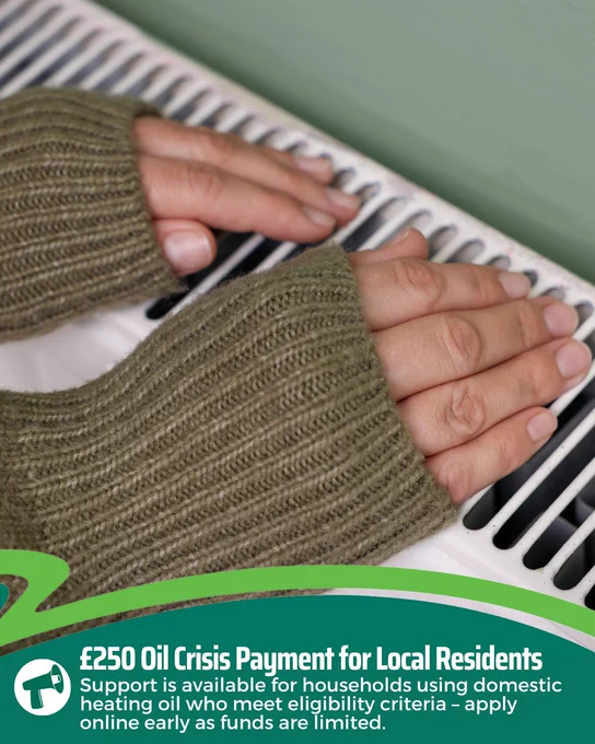 A person wearing a green knitted sweater warms their hands over a radiator. The text below reads: "£250 Oil Crisis Payment for Local Residents. Support is available for households using domestic heating oil who meet eligibility criteria – apply online early as funds are limited."