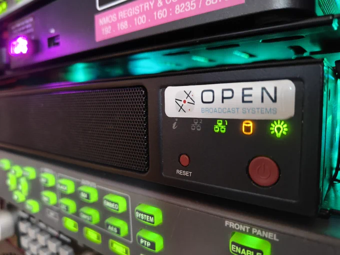 Closeup of the OBE server in the equipment rack. Pictured between 2 other devices with front panel lights. it's a very arty shot